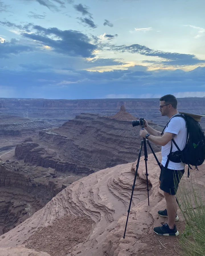 Jeff behind a tripod at the rim of a canyon in Utah at dusk